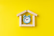 © Andrii - house symbol made wooden blocks with alarm clock inside. above view. outer space