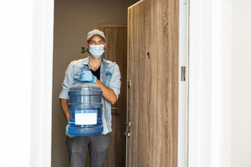 Wall Mural - Delivery water man wear protective face medical mask during coronavirus pandemia