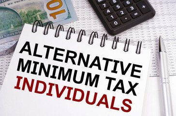 Wall Mural - On the table there is money, a calculator and a notebook with the inscription - Alternative Minimum Tax - Individuals