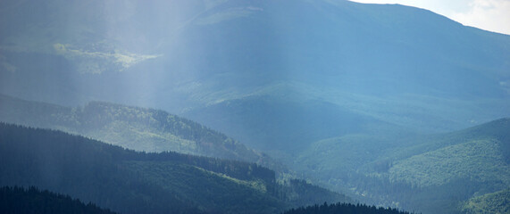 Wall Mural - sun rays and rain in the carpathian mountains in summer