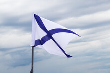 St. Andrew's Flag, White Flag With Blue Cross On Flagpole Against Cloudy Sky Background