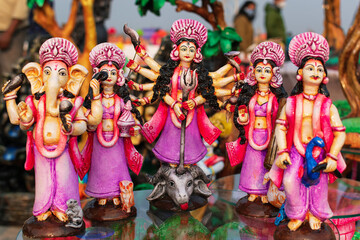 Beautiful handmade statuette of a Goddess Durga idol is displayed in a shop for sale in blurred background. Indian art and handicraft.(Selective focus)