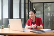 © Prathankarnpap - Young female entrepreneur having video call with her business partner.