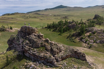 Wall Mural - Tourists on top of a cliff in the Tazheran steppes