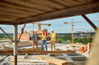 © zinkevych - Three workers in hardhats having a conversation on the construction site