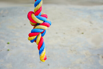 Color rope knot, three colors red, blue, yellow. The concept of bondage, connection, relationship pull the rope