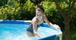 Happy girl child enjoy having fun in swimming pool on sunny summer day, recreation
