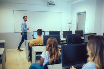 Poster - College students sitting in a classroom, using computers during class.