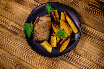 Wall Mural - Roasted beefsteak with the fried potato and parsley. Top view