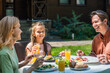© LIGHTFIELD STUDIOS - Positive family with food and orange juice talking during picnic