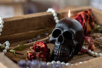 Black candle scull on witch table. Occult, esoteric, divination and wicca concept. Halloween, Day of the dead concept