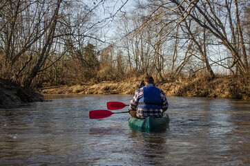 People boating on river in winter day, peacefull nature scene, Latvia.