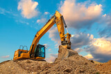 Fototapeta  - A stopping yellow excavator at stunning fluffy clouds