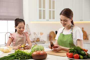 Sticker - Mother and daughter peeling vegetables at table in kitchen