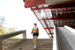 © Cavan Images - Student with backpack going down stairs outdoor