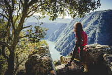 Woman With Red Backpack And Curly Hair Observing The Landscape Up High