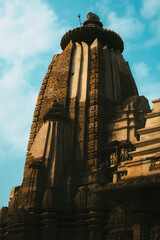 Poster - Vertical shot of a temple of Khajuraho on blue sky background in India