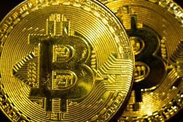 Sticker - Closeup shot of two gold bitcoins  illuminated with bright light