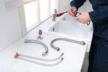 Poster - Professional plumber fixing water tap in kitchen, closeup