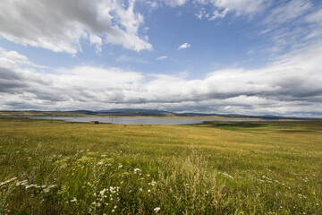 Wall Mural - Landscape and view of lake in Tsalka, Georgia. Green field and clouds.