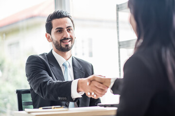 Business man shake hands with business women agreeing on partnerships or introducing themselves for first time meet