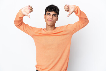 Young man over isolated white background showing thumb down with two hands