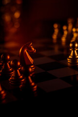 Poster - Vertical closeup shot of metal chessmen on a board illuminated with bright light