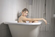 © Cavan Images - portrait of young beautiful woman in bathtub