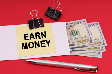 On a red background, an envelope with money and a sticker with the inscription - EARN MONEY