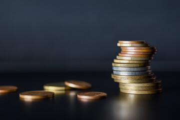 Tower of metal coins on black background