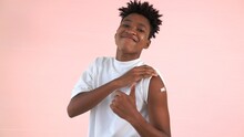 African American Teenager Showing COVID-19 Vaccine Bandage Merrily In Concept Of Coronavirus Vaccination Program To Vaccinate Citizen .