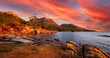 Landscape view of natural sea coast with mountain range in evening sunset  in orange-red and blue colors. Freycinet National Park Hazard mountain range, Freycinet National Park, Tasmania, Australia.