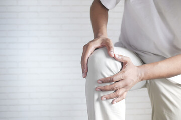 Wall Mural - Close up on man suffering knee joint pain with copy space 