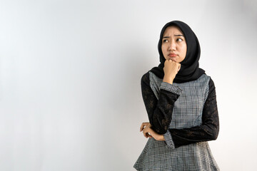 Beautiful young asian Muslim woman thinking and looking at empty space isolated on white background
