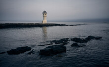 Rocks In Sea Near Lighthouse