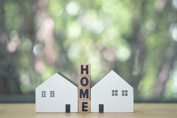 Wall Mural - Text of HOME on wooden block in middle of two miniature wood home.