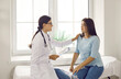 © Studio Romantic - Doctor talking to patient, comforting, supporting and reassuring her. Worried young woman having conversation with physician about health issues while sitting in exam room in modern clinic or hospital