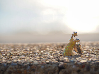 Wall Mural - Angel shape on gravel floor in bokeh of sea .Angel and miracle. Faith in God. Pray for you. Miracle from heaven. Believe in goddess. Christianity background concept.