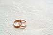 Gold wedding rings on a white surface with a beautiful decorative texture. Close-up.