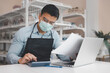 © Danai - Entrepreneur male business owner in eyeglasses with medical mask using computer laptop working in shop grocery store