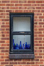 Window On Brick Wall With Blue Bottles