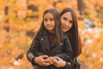 Wall Mural - Little girl playing with mother in the autumn park