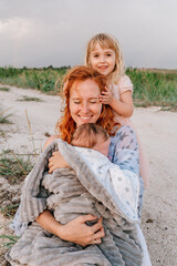 young woman mother with two daughters having fun time outdoor