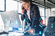 © VideoFlow - Businessman in suit has conference call to hire new employees for international business consulting. HR, social media hologram icons and interconnections over office background with panoramic windows