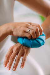 Wall Mural - Wrist Pain Treatment. Woman Holding Ice Bag Compress on a Painful Wrist.