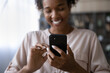 © fizkes - Crop close up focus of smiling African American woman use cellphone talk speak on video call on gadget. Happy ethnic female hold gadget text message on smartphone or have webcam digital event.