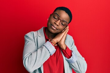 Sticker - Young african american woman wearing business jacket and glasses sleeping tired dreaming and posing with hands together while smiling with closed eyes.