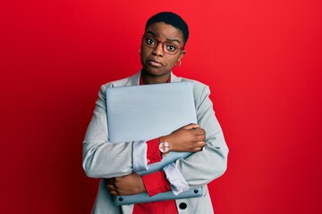 Canvas Print - Young african american businesswoman holding laptop depressed and worry for distress, crying angry and afraid. sad expression.