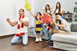 © Krakenimages.com - Group of young friends watching and supporting soccer match at home.