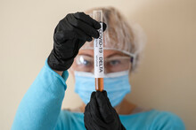 Woman In Protective Suit Hold Test Tube With Sample Of Analysis Suspected With Delta Coronavirus Variant COVID-19